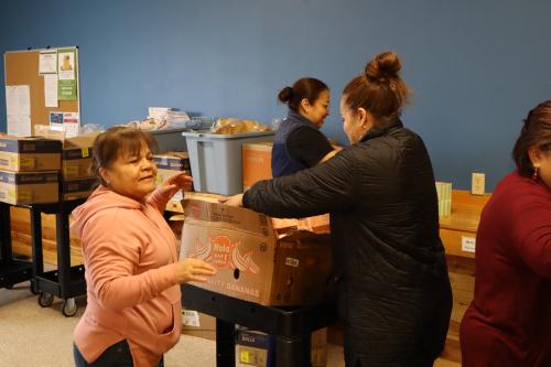 A group of women putting food in boxes